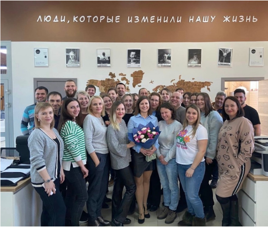 Команда ТентОПТ в офисе, где размещена фотография CODE9 и надпись люди, которые изменили нашу жизнь